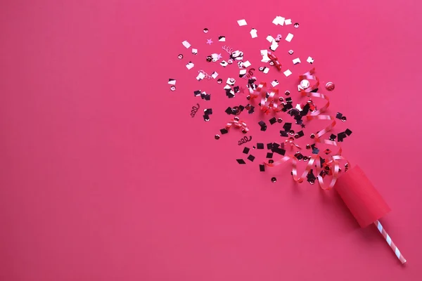 Glanzende Confetti Slingers Met Party Cracker Roze Achtergrond Bovenaanzicht Ruimte — Stockfoto