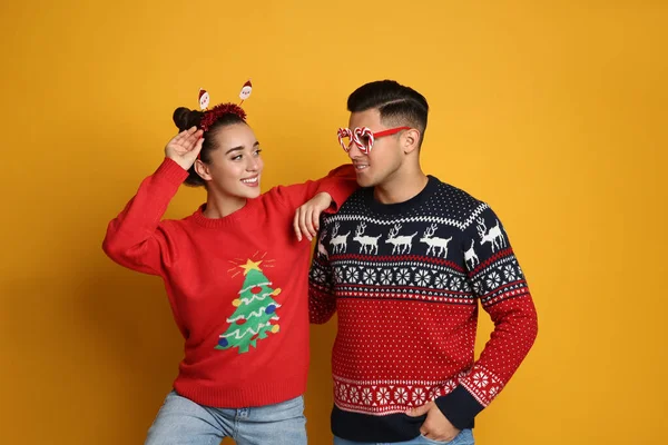 Pareja Suéteres Navidad Diadema Santa Gafas Fiesta Sobre Fondo Amarillo —  Fotos de Stock