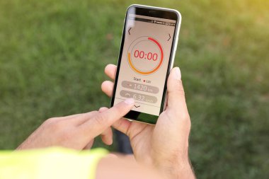 Dışarıdaki akıllı telefondan spor uygulaması kullanan bir adam.