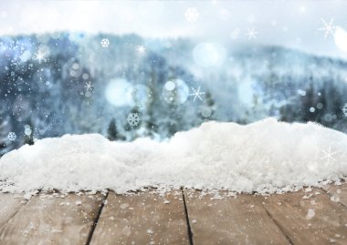 Arkaplanda karlı tahta ve bulanık orman var. Noel zamanı