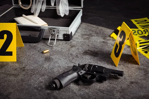 灰色の石のテーブルの上のシェルケース 銃と犯罪現場マーカー — ストック写真
