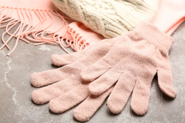 Stylish pink gloves, scarf and hat on light grey marble table, closeup