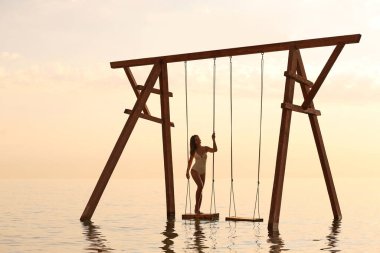 Suyun üzerinde güneşin doğuşunu seyreden genç bir kadın.