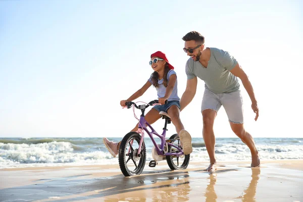 Feliz Padre Enseñando Hija Montar Bicicleta Playa Arena Cerca Del — Foto de Stock