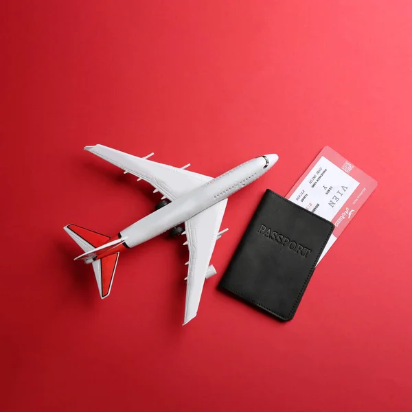 Avião Brinquedo Passaporte Com Bilhete Fundo Vermelho Flat Lay — Fotografia de Stock