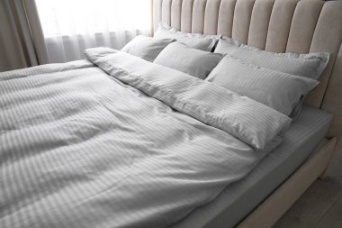 Yumuşak battaniyeli ve yastıklı rahat bir yatak.