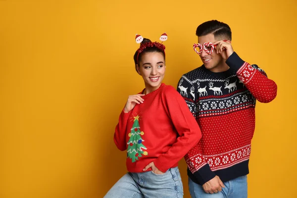 Paar Weihnachtspullover Weihnachtsmann Stirnband Und Partybrille Auf Gelbem Hintergrund Platz — Stockfoto