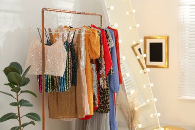 Farklı tarz kadın kıyafetleri ve aynalarla donatın.