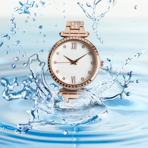 Luxury women\'s watch in water splashes demonstrating its waterproof
