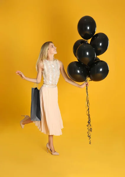 Vrolijke Jonge Vrouw Met Ballonnen Boodschappentas Gele Achtergrond Zwarte Vrijdag — Stockfoto