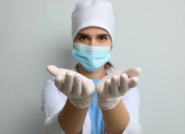 Dokter Beschermend Masker Medische Handschoenen Tegen Lichtgrijze Achtergrond Focus Handen — Stockfoto