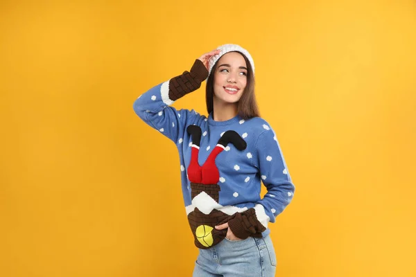 Sarı Arka Planda Noel Süveteri Şapkalı Genç Bir Kadın — Stok fotoğraf