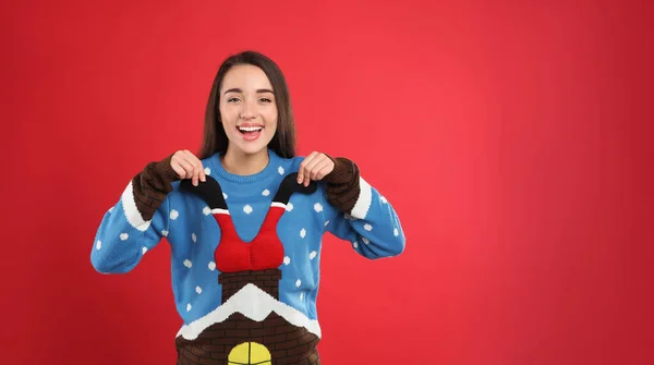 Kırmızı Arka Planda Noel Süveteri Giyen Genç Kadın Mesaj Için — Stok fotoğraf
