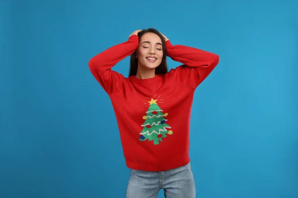 若いです女性でクリスマスセーター上の青の背景 — ストック写真