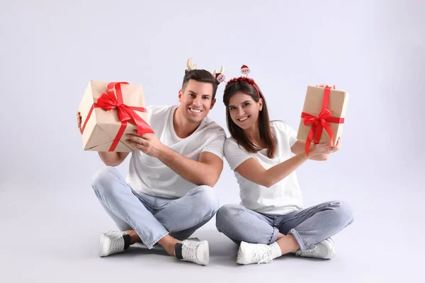 Schöne Glückliche Paar Weihnachten Stirnbänder Sitzen Mit Geschenken Auf Hellem — Stockfoto