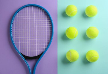Tenis raketi ve renkli arka planda toplar, düz yatış. Spor malzemeleri.