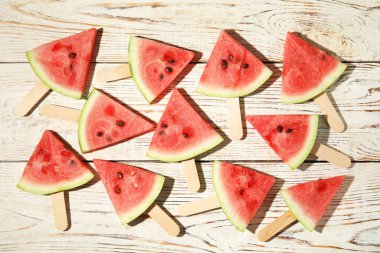 Olgun karpuz dilimleri beyaz ahşap masada, düz yatıyordu.