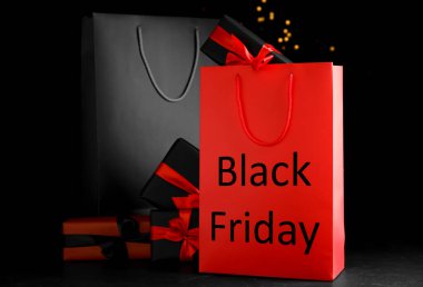 Bulanık ışıklara karşı kağıt alışveriş torbaları ve hediye kutuları. Kara Cuma indirimi