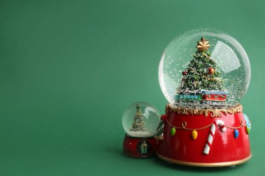 Yeşil zemin üzerinde Noel ağaçları olan güzel kar küreleri, metin için boşluk