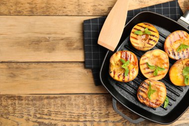 Ahşap masada naneli ızgara şeftali, düz. Metin için boşluk