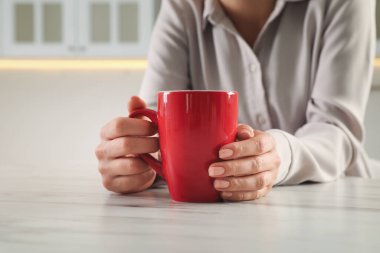İçerideki masada kırmızı bardaklı kadın, yakın plan.