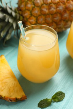 Açık mavi ahşap masada nefis taze ananas suyu