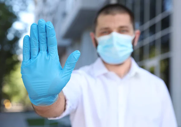 Man Met Beschermend Gezichtsmasker Toont Stop Gebaar Buiten Focus Hand — Stockfoto