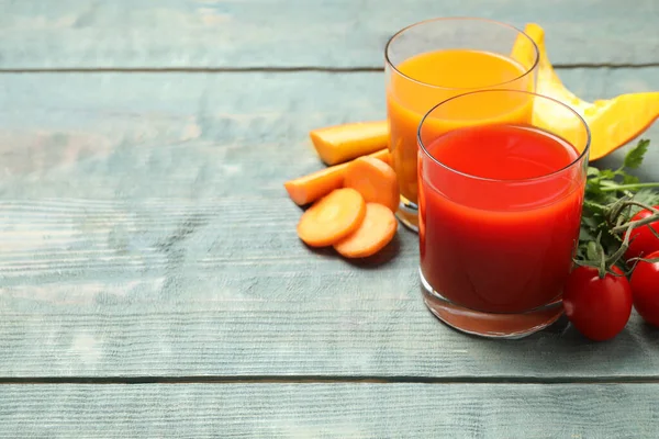 Lezzetli sebze suları ve mavi ahşap masada taze malzemeler. Metin için boşluk