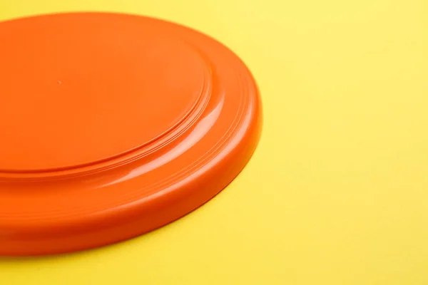 Disco Frisbee Plástico Naranja Sobre Fondo Amarillo Primer Plano Espacio — Foto de Stock