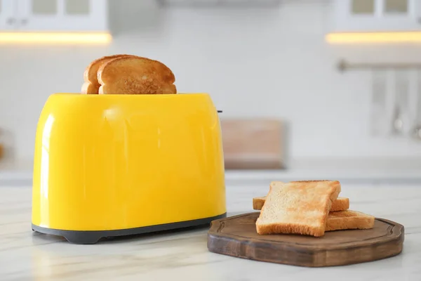 厨房白色大理石桌上的现代烤面包机和面包片 — 图库照片