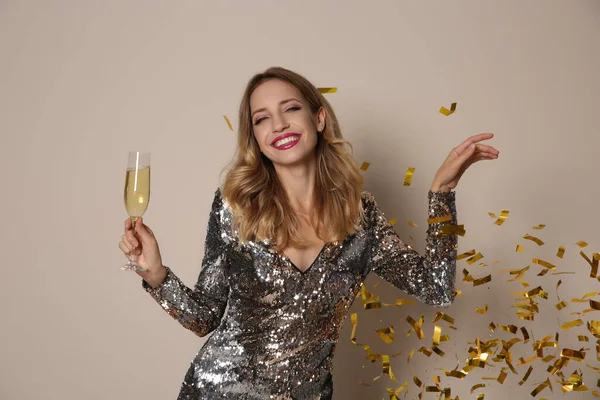 Vrolijke Vrouw Met Glas Champagne Confetti Beige Achtergrond Kerstfeest — Stockfoto