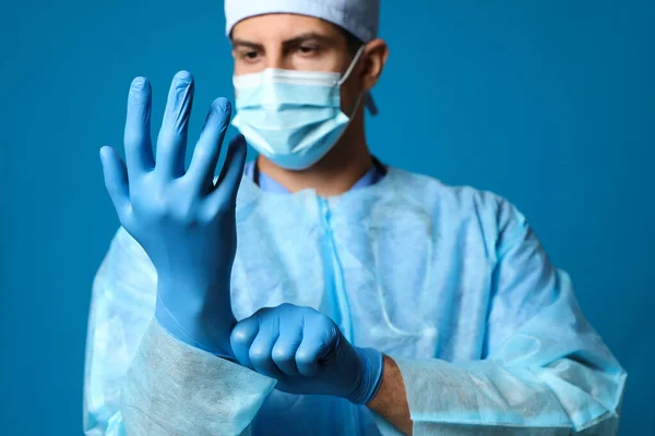 Koruyucu Maskeli Doktor Mavi Arka Planda Tıbbi Eldiven Takıyor — Stok fotoğraf