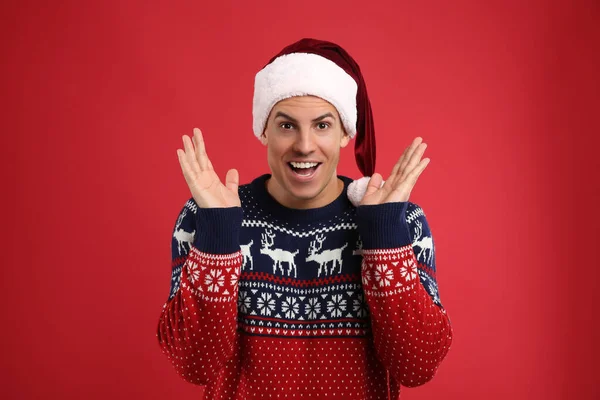 Excited Man Christmas Sweater Santa Hat Red Background — Stock Photo, Image