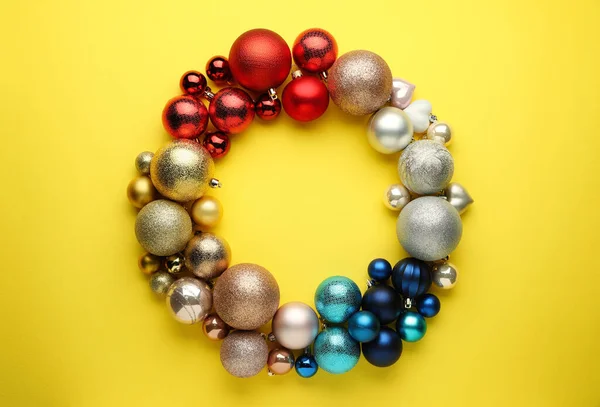 Heldere Feestelijke Krans Gemaakt Van Kerstballen Gele Achtergrond Bovenaanzicht Ruimte — Stockfoto