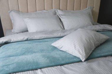 Yumuşak battaniyeli ve yastıklı rahat yatak, yakın çekim.