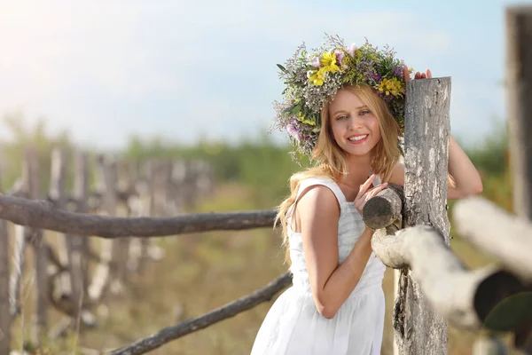Ung Kvinna Bär Krans Gjord Vackra Blommor Nära Trästaket Solig — Stockfoto