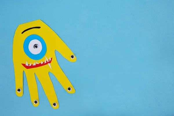 Funny Yellow Hand Shaped Monster Light Blue Background Top View —  Fotos de Stock