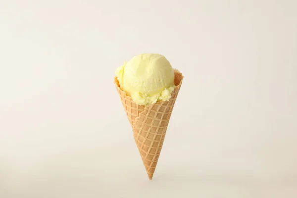 白色背景华夫饼筒中美味的黄色冰淇淋 — 图库照片