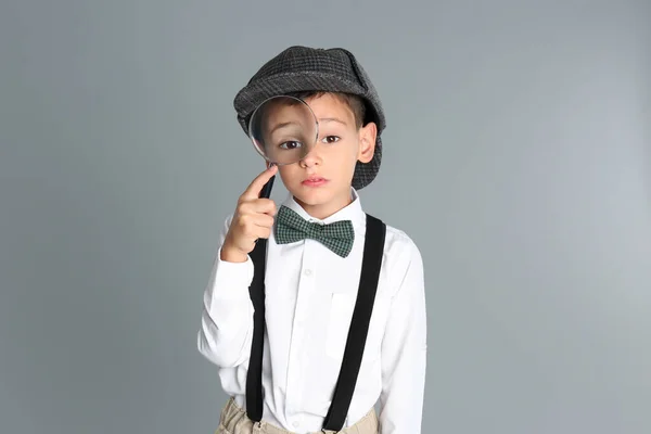 Маленький Хлопчик Збільшувальним Склом Грає Детектива Сірому Фоні — стокове фото