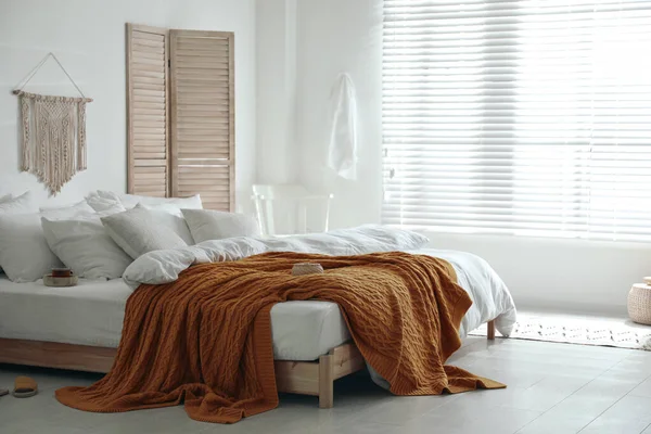 スタイリッシュな部屋のインテリアで再生暖かいニットと快適なベッド — ストック写真