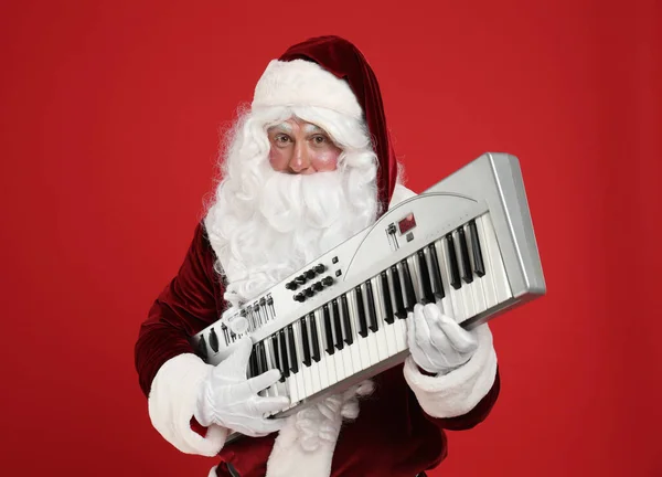 Święty Mikołaj Syntezatorem Czerwonym Tle Muzyka Świąteczna — Zdjęcie stockowe