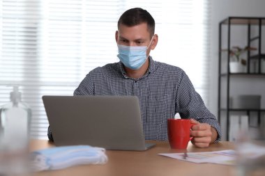 Ofiste maskeli bir işçi. COVID-19 salgını sırasında koruyucu önlem
