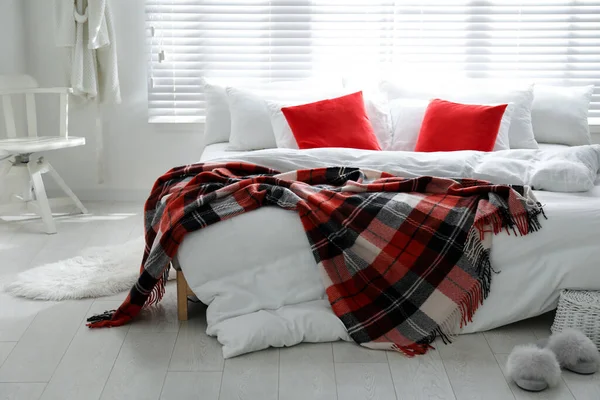 スタイリッシュなお部屋のインテリアで温かみのあるチェッカー付きの快適なベッド — ストック写真