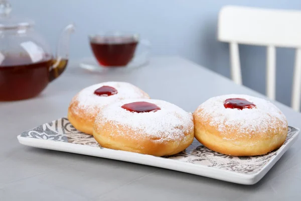 Hanukkah doughnuts with jelly and sugar powder served on grey table