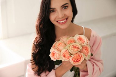 Mutfakta güzel buketi olan genç bir kadın.