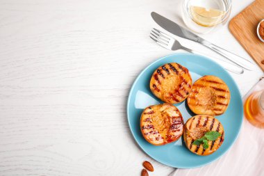 Beyaz masada bal ve nane aromalı nefis ızgara şeftali, düz. Metin için boşluk