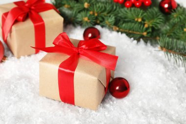 Noel hediyesi kutusu ve dekorasyon masasında suni kar, yakın plan.