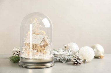 Güzel kar küresi ve açık gri taş masada Noel süsü. Metin için boşluk