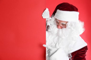 Kırmızı arka planda boş pankart tutan Noel Baba
