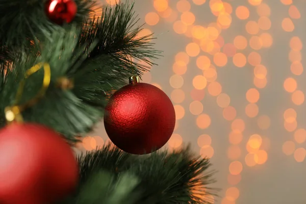 挂在圣诞树上的红色假日便宜货在模糊的节日灯火下 案文的篇幅 — 图库照片